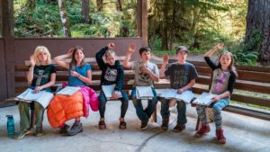 outdoor school students raising their hands