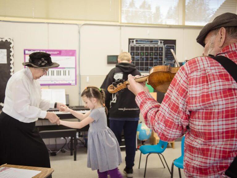 Fiddle player visiting a classroom