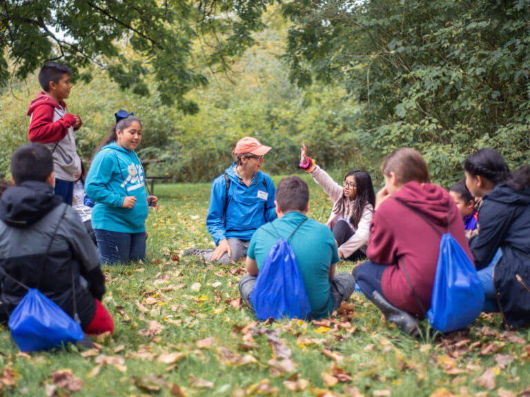 students with teacher in a field