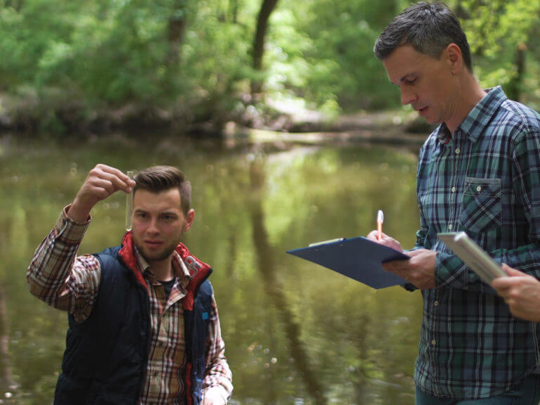 Two men record river data