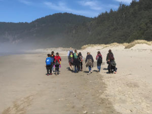 students and teachers walking down a beach