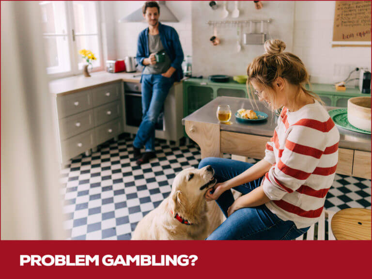 two people standing in a small kitchen with a dog