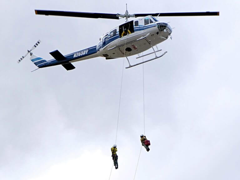 Rappellers descend from helicopter