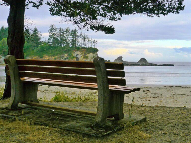 View of Sunset Bay State Park coast from behind a bench overlook point