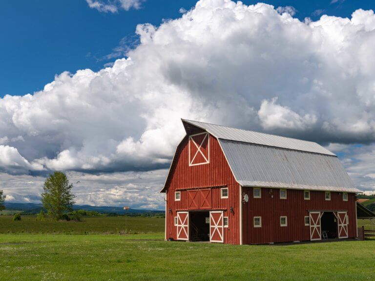 blue sky and white clouds over a red barn in Polk County