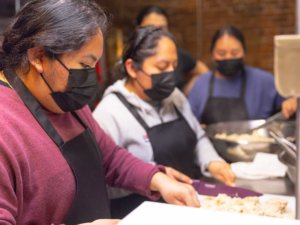 Women prep food in a commercial kitchen