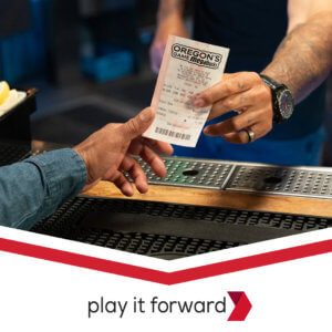 A clerk hands a Megabucks ticket to a customer