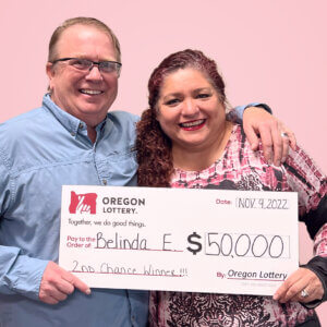 Belinda E holding a check