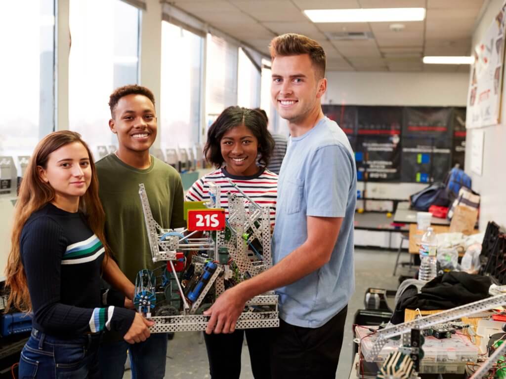 A group of four students work on a robotics project