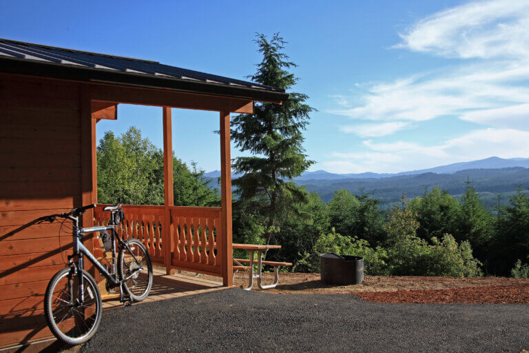 A bike leans against the side of a cabin
