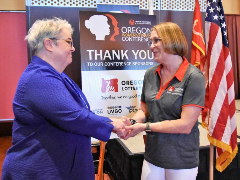 ODVA Director Kelly Fitzpatrick shakes hands with Kathy Stromberg from the Oregon Lottery.