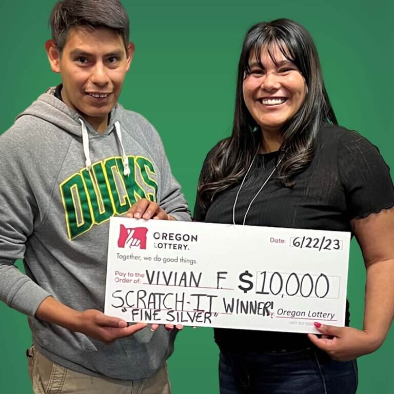 Scratch-it winner Vivian holding a check with her brother Frako