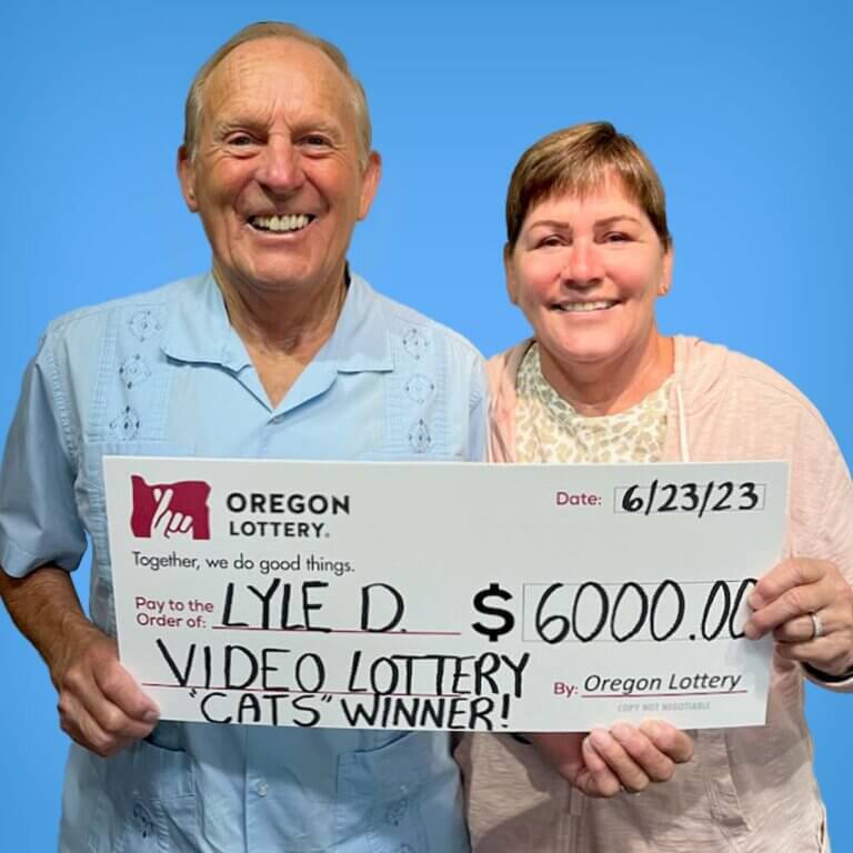 Cats Video Lottery winner Lyle D and his wife holding a check