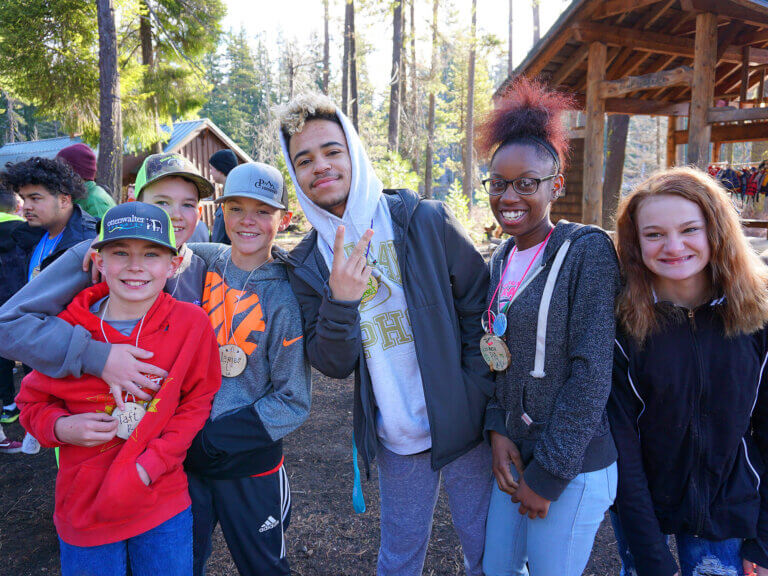 A student leader poses with younger kids at Camp Tamarack