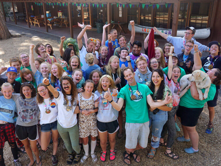 A large group of students and leaders pose outdoors at Camp Tamarack.
