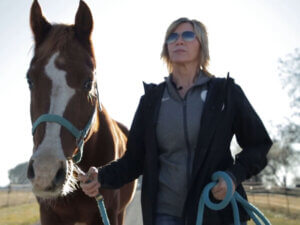 A woman leads a horse.