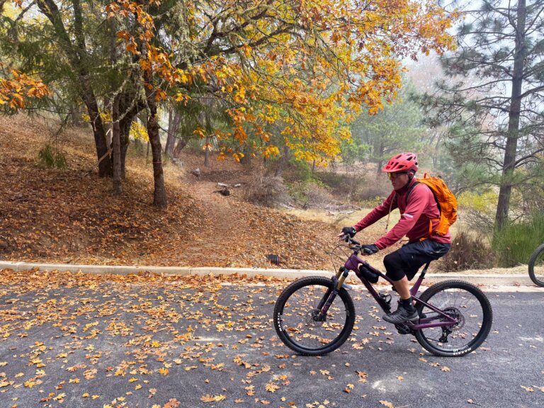 A man rides a mountain bike across a parking lot