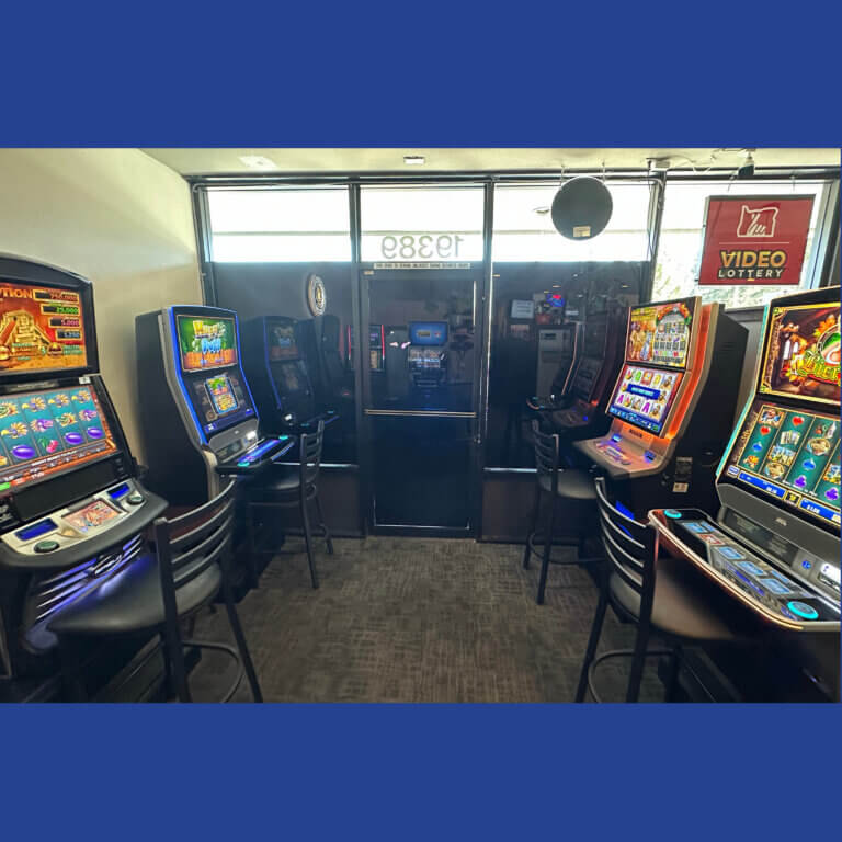 Interior of a restaurant's Video Lottery play area. There are 4 video lottery terminals, 2 against each wall with a Video Lottery sign in the window above them