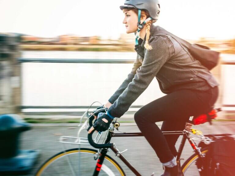 A woman rides her bike along a Portland riverfront.